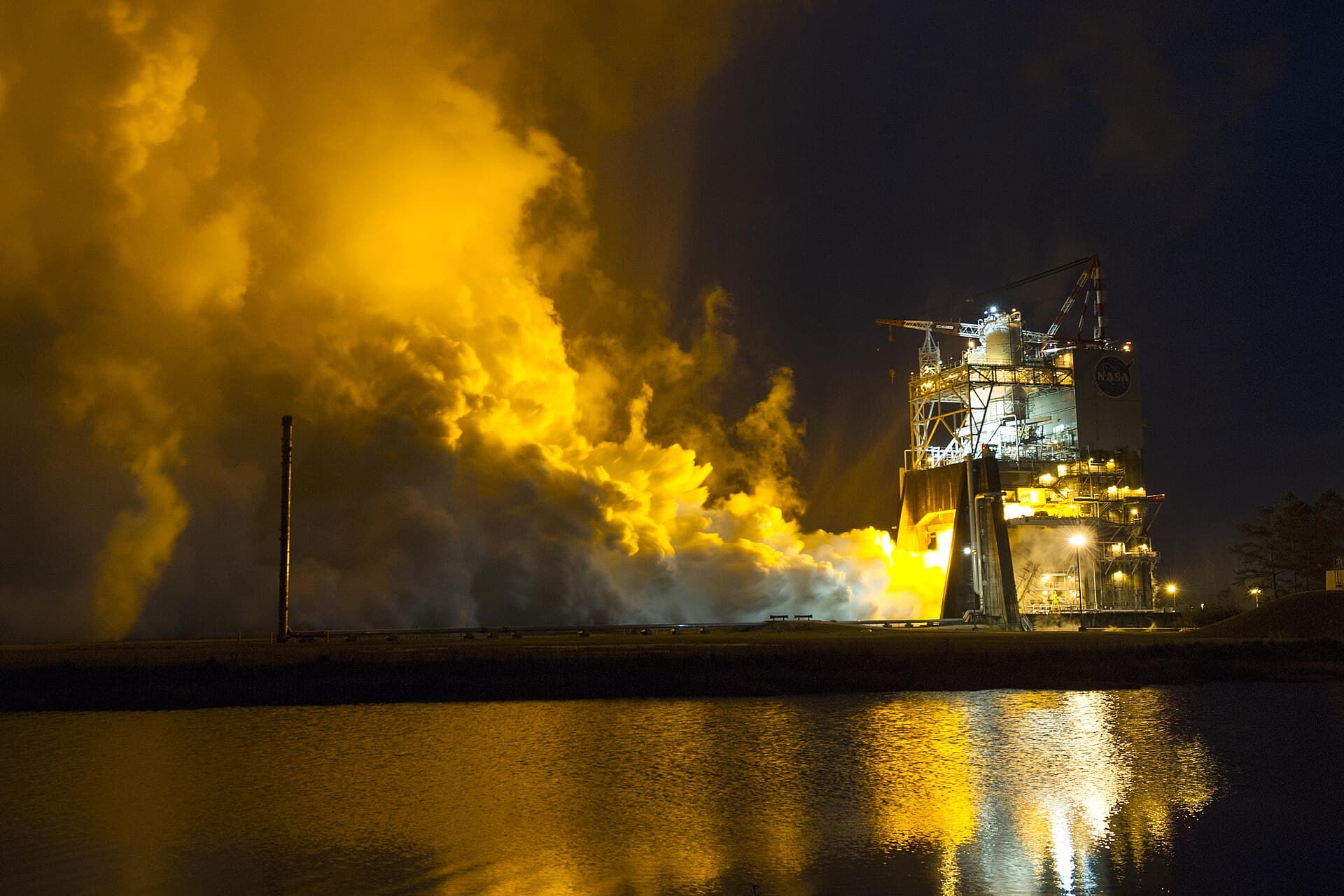 Essai de nuit d'un moteur-fusée : le panache illumine le banc d'essai